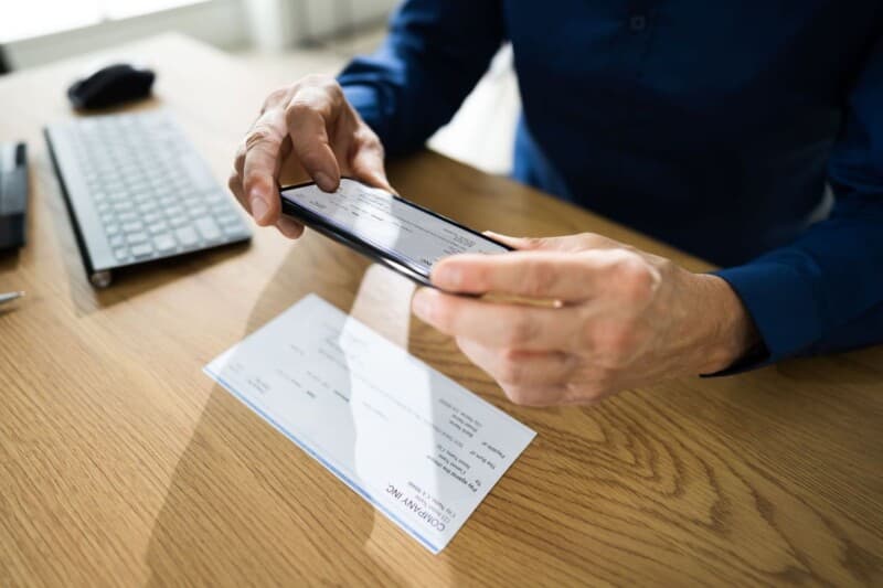 A person taking a picture of his check