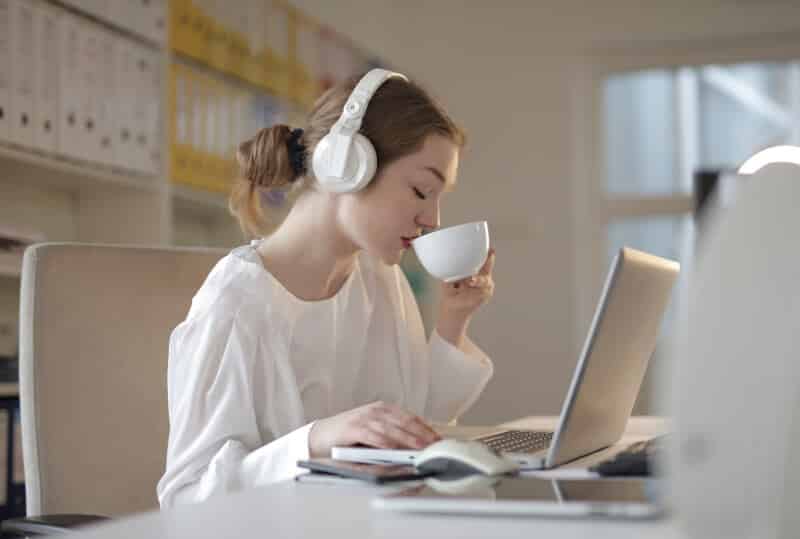 Woman Listening to Music while Drinking Coffee and Working