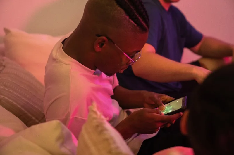 Guy Playing Game on Cellphone on Party