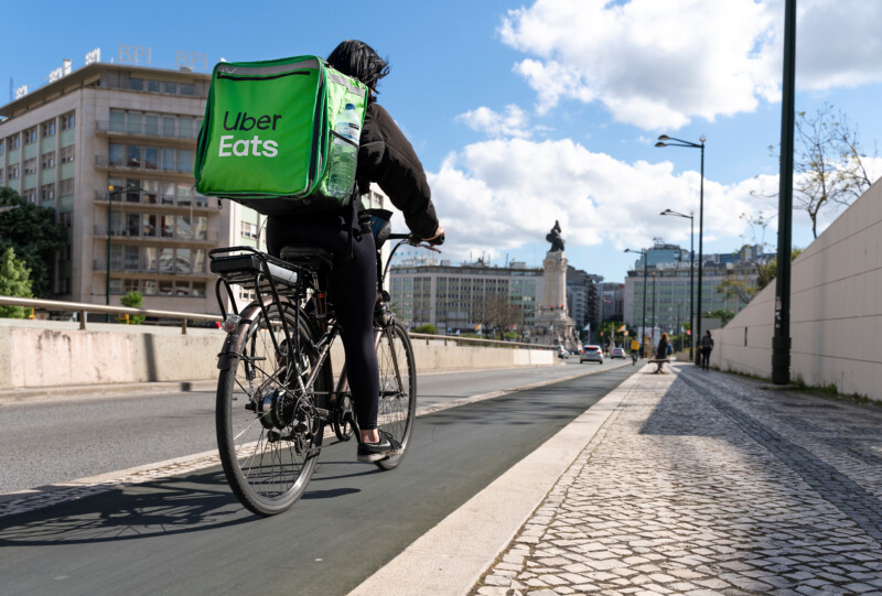 Uber Eats food delivery man on the bicycle delivering in the city center of Lisbon, Portugal