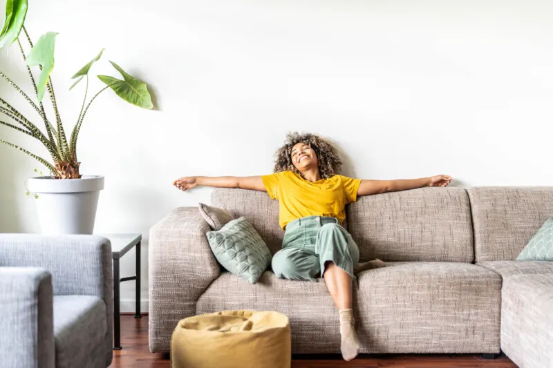 Happy afro american woman relaxing on the sofa at home