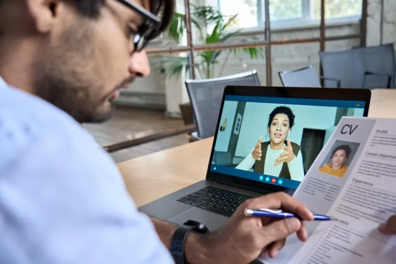 Indian human resource manager holding cv having virtual job interview conversation with remote female candidate during distant business video call on laptop computer