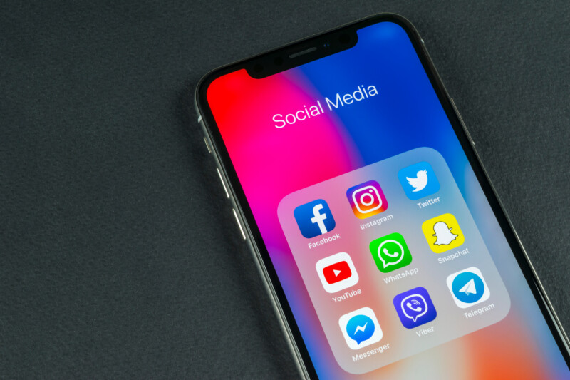 Apple iPhone X with icons of social media facebook, instagram, twitter, snapchat application on screen