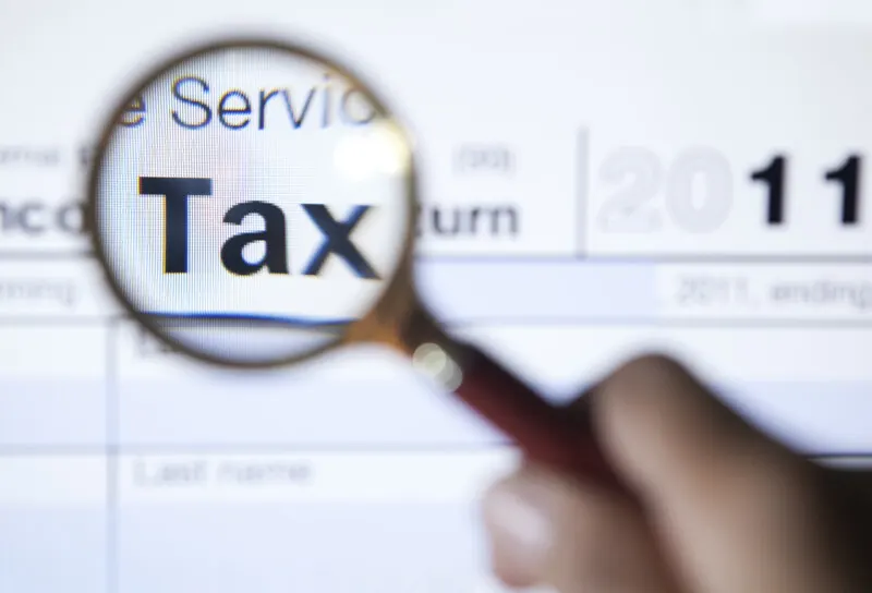 Magnifying Glass Over The Word Tax On Form 1040